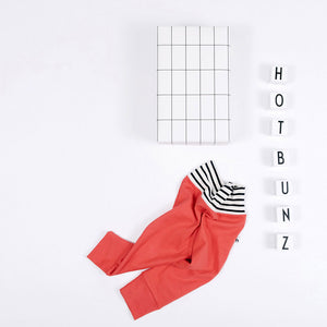 flat lay of red baby pants with stripe waistband  