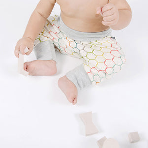 seated baby with multicolored drop-crotch pants