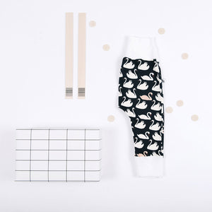 flat lay of baby pants with swan prints