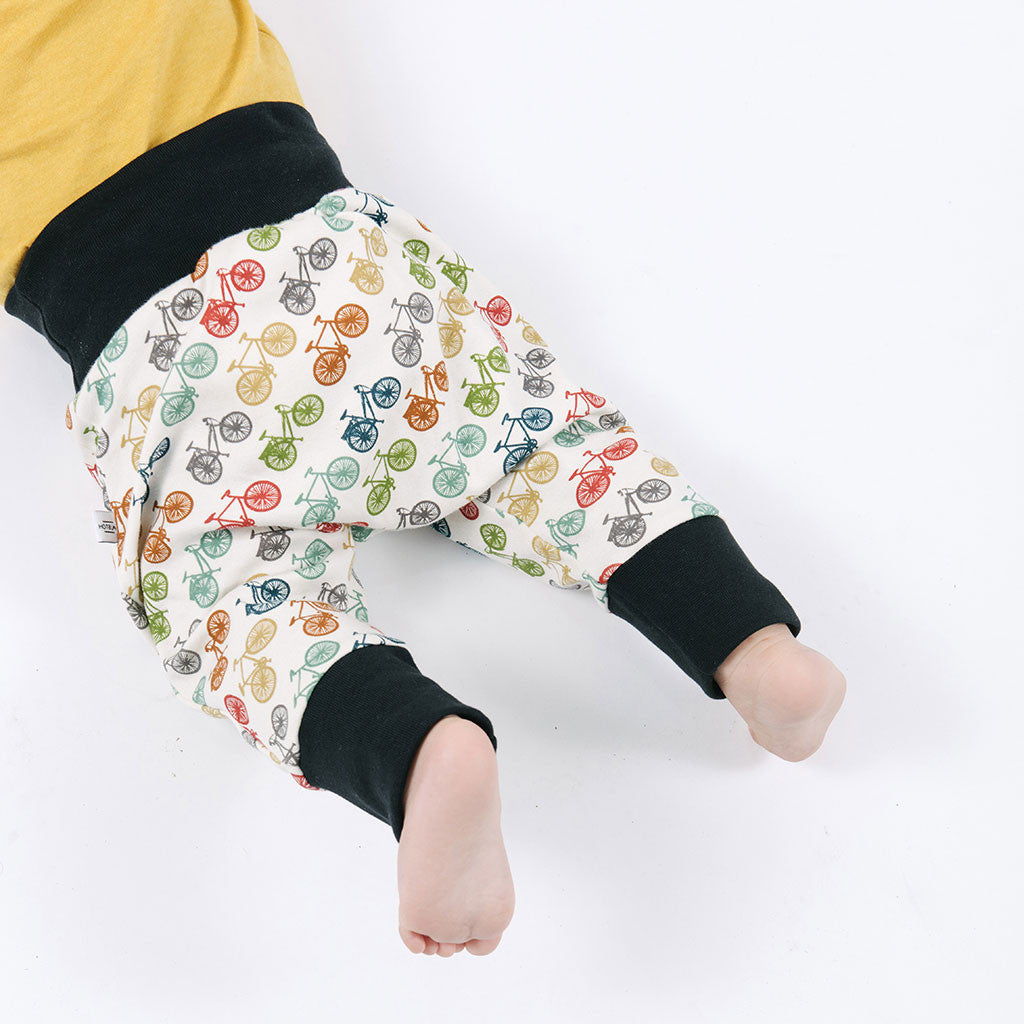 baby legs in multicolored pants with bicycles prints